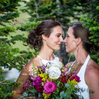 two lesbian brides share an intimate moment among the pines at 12,000 feet in rmnp